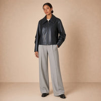 Veste en cuir et microfibre à grand col pointu SAKIWE noire portée de face, main dans la poche