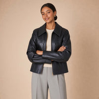 Veste en cuir et microfibre à grand col pointu SAKIWE noire portée bras croisés