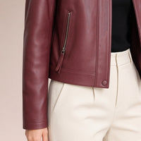 Détail de la poche zippée et de la manche de la veste en cuir rouge vin