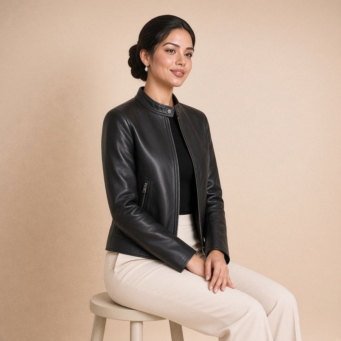 Veste courte en cuir de mouton à col montant noire portée, assise