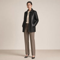 Veste mi-longue en cuir de mouton noir SAKIWE de trois quarts, mains dans les poches