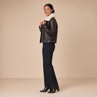 Veste courte ouatinée en cuir de mouton à col peluche SAKIWE brun expresso, de profil, mains sur le col
