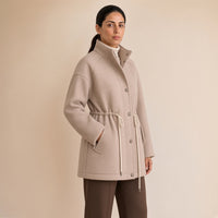 Veste mi-longue jacquard à col montant et taille coulissée, beige avoine, vue de trois-quarts – SAKIWÉ